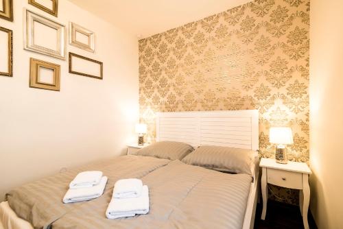 a bedroom with a bed with two towels on it at Penzion Pumpion in Valtice