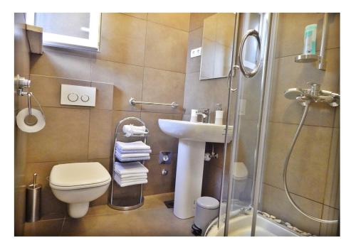 y baño con aseo, lavabo y ducha. en Guest House Varos, en Split