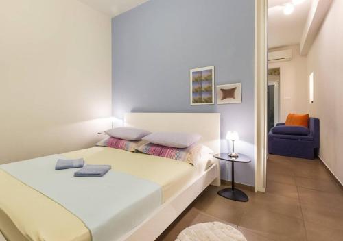 1 dormitorio con 1 cama blanca y 1 silla azul en Guest House Varos, en Split