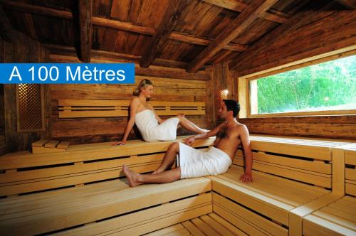 a man and woman sitting in a sauna at Résidence des Châteaux in Ottrott