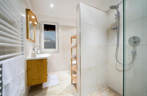 ein Bad mit einer Dusche und einem Waschbecken in der Unterkunft Kasperhof Apartments Innsbruck Top 6 - 7 in Innsbruck