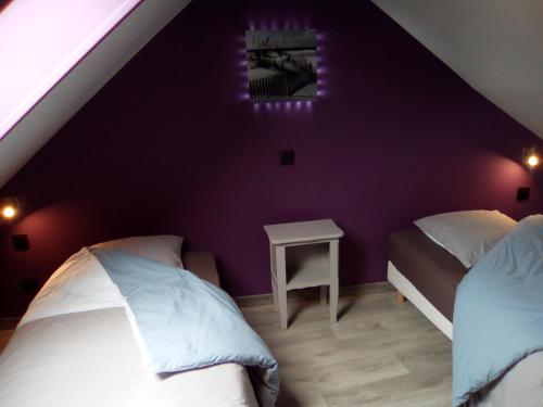 - une chambre avec 2 lits et un mur violet dans l'établissement Chez ma tante, à Méneslies