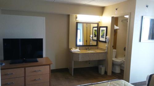 a hotel room with a bathroom with a sink and a television at Extended Stay America Suites - Houston - Med Ctr - NRG Park - Braeswood Blvd in Houston