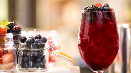 a vase filled with berries and a drink at River Terrace Inn, a Noble House Hotel in Napa
