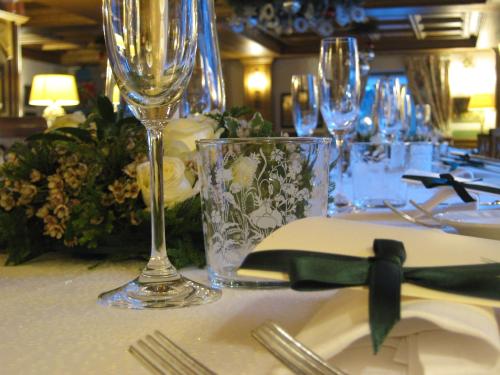 a table with wine glasses and a plate with a napkin at Auberge de La Maison in Courmayeur