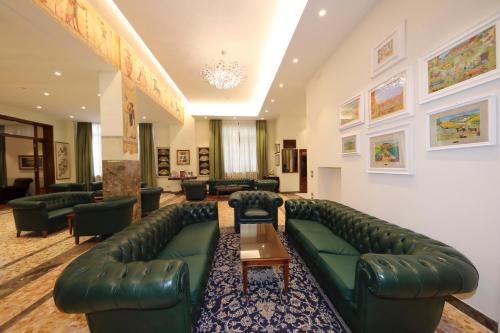 a large living room with a green leather couch at Hotel Moderno in Siena