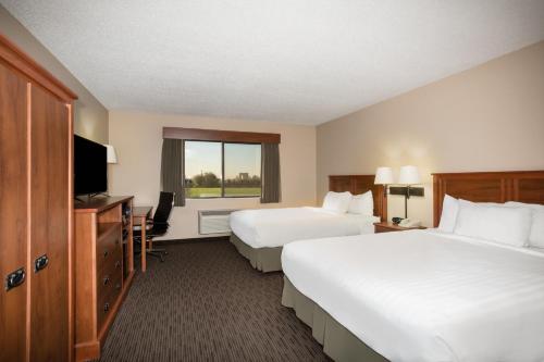 a hotel room with two beds and a television at AmericInn by Wyndham Sioux City in Sioux City