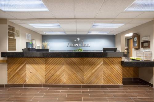 a waiting area of a merriott hospital with a reception counter at AmericInn by Wyndham Sioux City in Sioux City