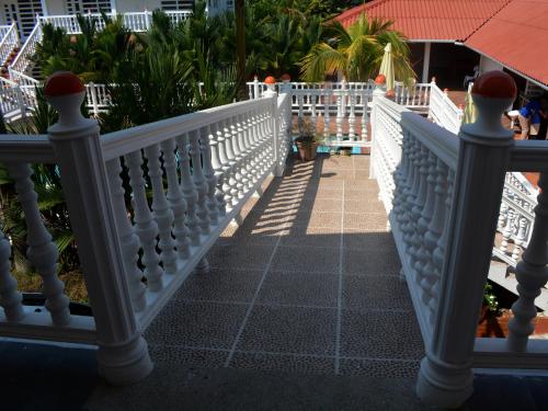 a white railing on a porch with trees and plants at Hotel Campestre La Toscana in Villavicencio