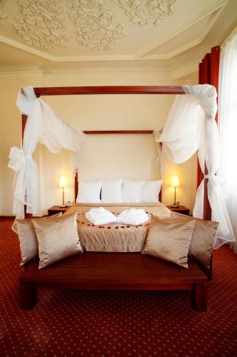 a bedroom with a large bed with white curtains at Monika Centrum Hotels in Rīga
