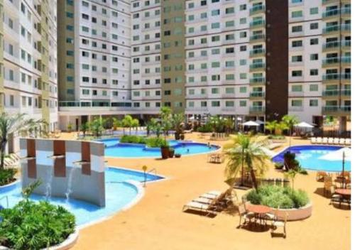 a resort with two pools and chairs and buildings at Thermas Riviera Park in Caldas Novas