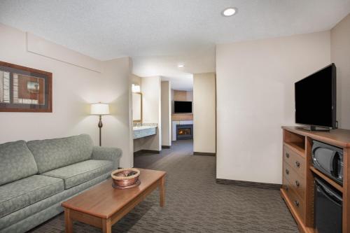 a living room with a couch and a tv at AmericInn by Wyndham Sioux City in Sioux City