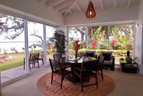 a dining room with a table and chairs in a living room at Ocean Point Villa in Saraotou