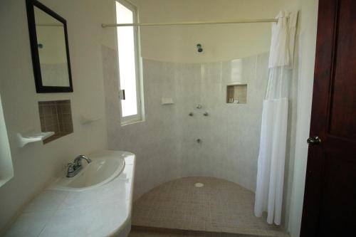 Eco-Hotel Nueva Altia في Santa Elena: حمام أبيض مع حوض ومغسلة
