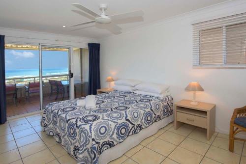 a bedroom with a bed, a desk and a window at Samarinda Jewel by the Sea in Point Lookout