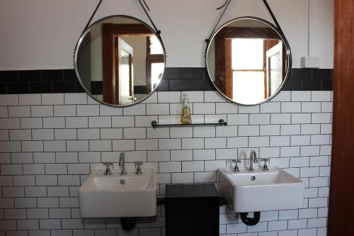 two sinks in a bathroom with two mirrors at Guildford Hotel in Guildford