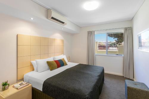 a bedroom with a large bed and a window at Nesuto Geraldton in Geraldton