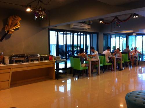 a group of people sitting at tables in a restaurant at The BluEco Hotel SHA Plus in Kata Beach