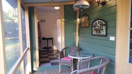a porch with two chairs and a table on a house at Blair Athol Homestead in Inverell