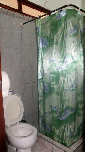 a bathroom with a toilet and a shower curtain at AC Room 2 Persons Hospedaje Don Wilfredo in San Juan del Sur