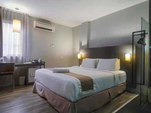 Un pat sau paturi într-o cameră la The Leverage Business Hotel - Rawang