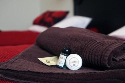 a brown blanket on a bed with a bottle of medicine at Hotel Altamira in Piotrków Trybunalski