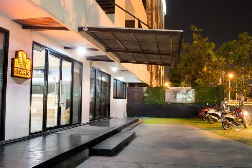 a building with a bench in front of it at night at Star 3 Hotel and Residence in Rayong