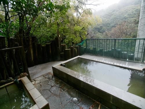 a pool of water sitting next to a fence at Minshuku Unzen in Unzen