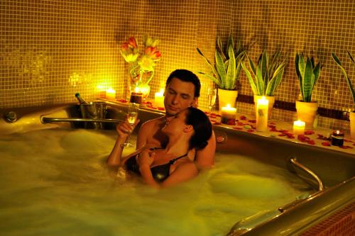 Ein Mann und eine Frau sitzen in einer Badewanne in der Unterkunft Seasons SPA Boutique Hotel in Kozin