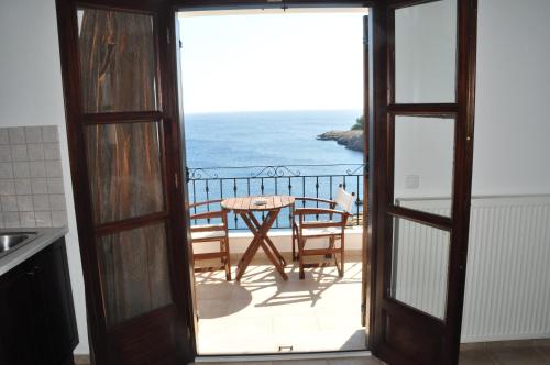 a balcony with a table and a view of the ocean at Yalis Hotel in Votsi
