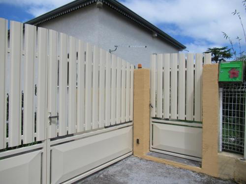 a white fence in front of a house at Boule de bleu in Le Tampon