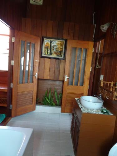 a bathroom with two doors and a sink at Hidden Holiday House in Ban Don Faek