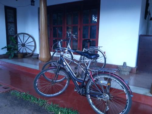 two bikes are parked outside of a house at Saubagya Inn in Anuradhapura