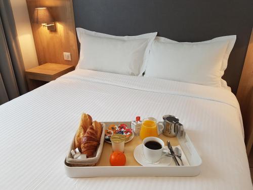 a tray of breakfast food on a bed at H&ocirc;tel Mary's - Caen Centre Gare Sncf in Caen