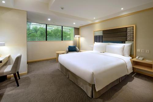 a large bedroom with a large white bed and a desk at Sonnien Hotel in Taipei