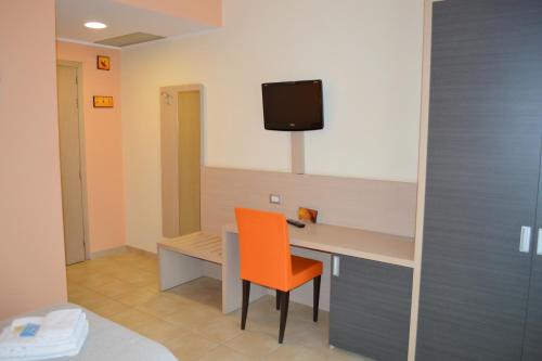 a room with a desk with a chair and a tv at La Lanterna Hotel in Rometta Marea