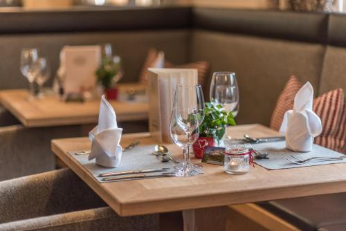 a table in a restaurant with glasses and napkins at Hotel Lindenhof in Ramsau am Dachstein