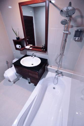 a bathroom with a sink and a bath tub at Nonghan Grand Hotel and Resort in Nong Han