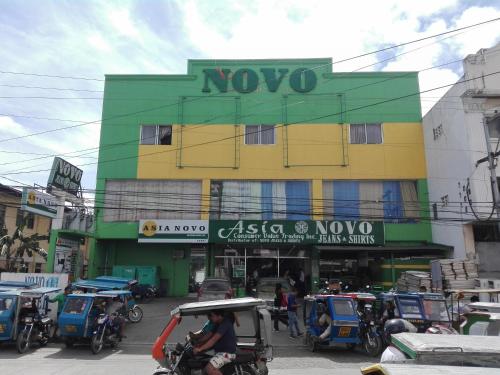 un edificio en una concurrida calle de la ciudad con gente en Asia Novo Boutique Hotel - Kalibo en Kalibo