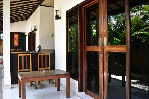 a wooden door with a bench in front of a house at Meisya Cottage in Gili Trawangan