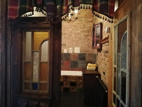 a bathroom with a brick wall and a mirror at DOM GOŚCINNY PTASZARNIA - NATURA-Free PARKING in Świnoujście