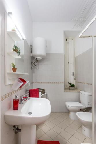 a white bathroom with a sink and a toilet at Sicily Mon Amour Ortigia in Syracuse