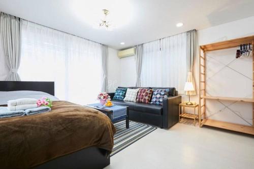 a bedroom with a bed and a couch at Luxury Guest House in Tokyo Shinjuku in Tokyo