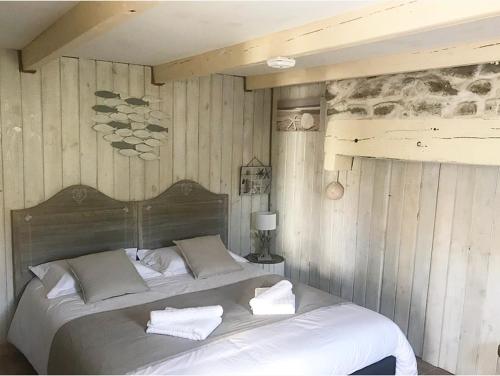 a bedroom with a large bed with towels on it at Île ô des capucins in Roscanvel