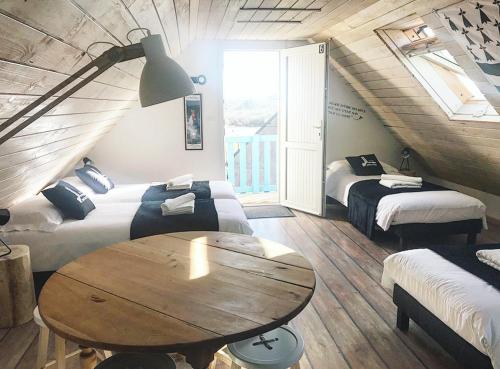a room with two beds and a table in it at Île ô des capucins in Roscanvel