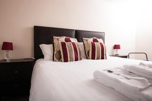 a bedroom with a white bed with pillows and two lamps at Bridge Hotel Brandon in Brandon
