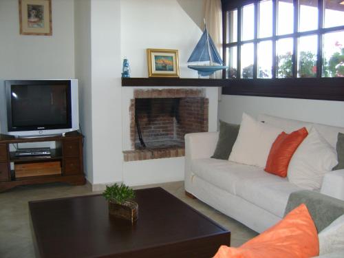 a living room with a couch and a tv at Yalis Hotel in Votsi