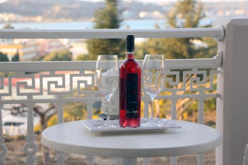 una botella de vino sentada en una mesa con dos copas en Miva Sea View, en Faliraki