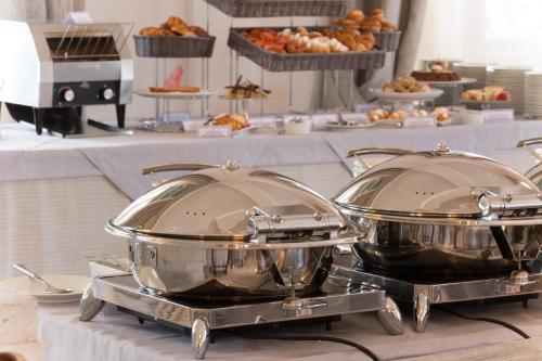 two large silver pots sitting on a table with food at Imperiale Palace Hotel in Santa Margherita Ligure