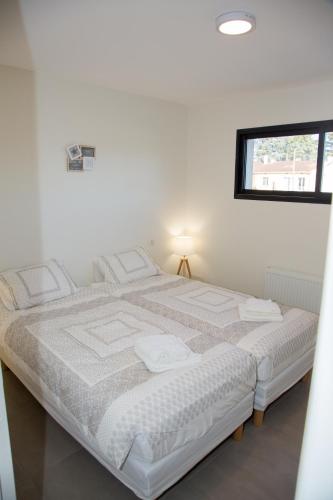 a white bed in a room with a window at Albipavillon in Albi